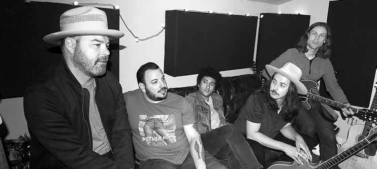 Black-and-white photograph of The Coffis Brothers band in a recording studio, with a guitar and piano.